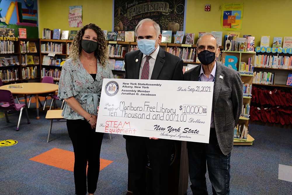 Assemblyman Jonathan Jacobson presents a $10,000 check to Marlboro Free Library Director Christina Jennerich that will be used to enhance their STEAM program for children. Supervisor Al Lanzetta was on hand to thank Jacobson.